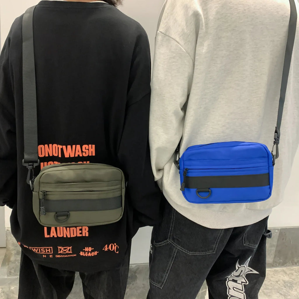 Men's solid colour nylon messenger bag with crossbody strap, shown in street style.