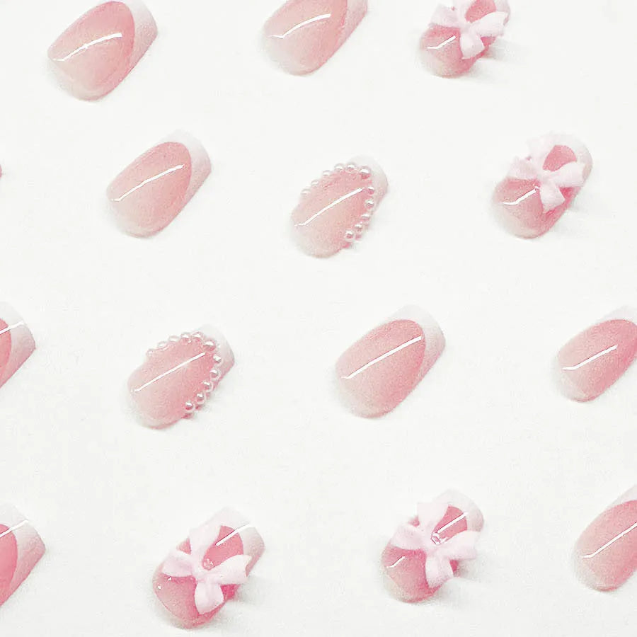 Set of short white French style press-on nail stickers with cute bow and tulip designs.
