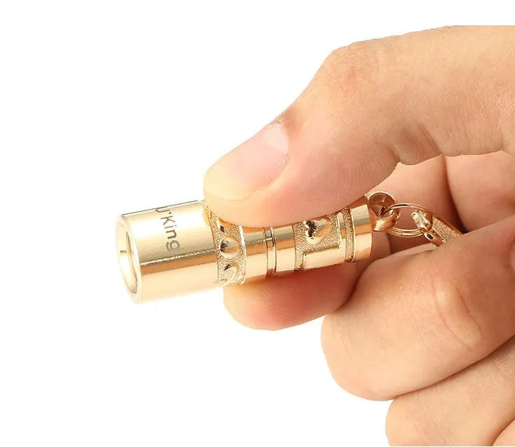 Gold zinc alloy waterproof LED flashlight attached to keychain with compact portable design