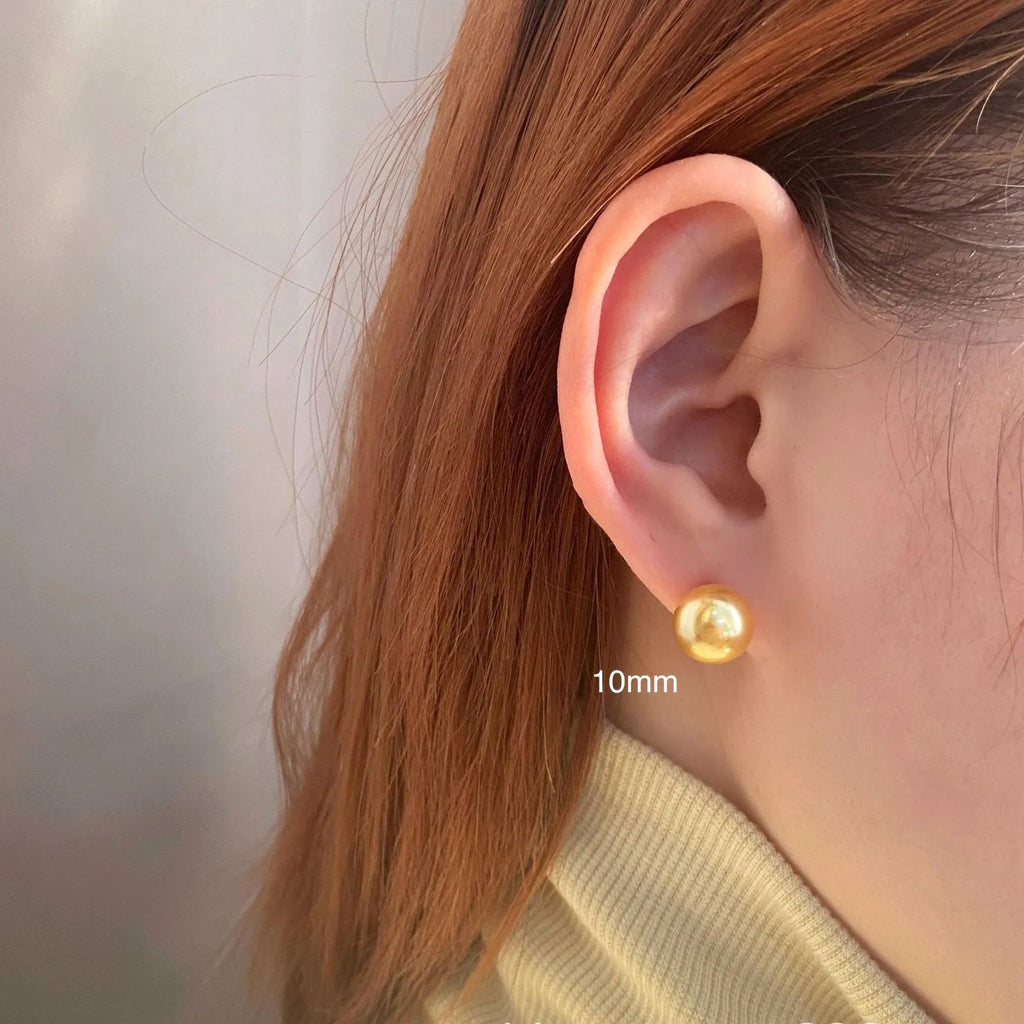 A pair of large geometric pearl stud earrings for women in silver, showing an eight-point star design detail.