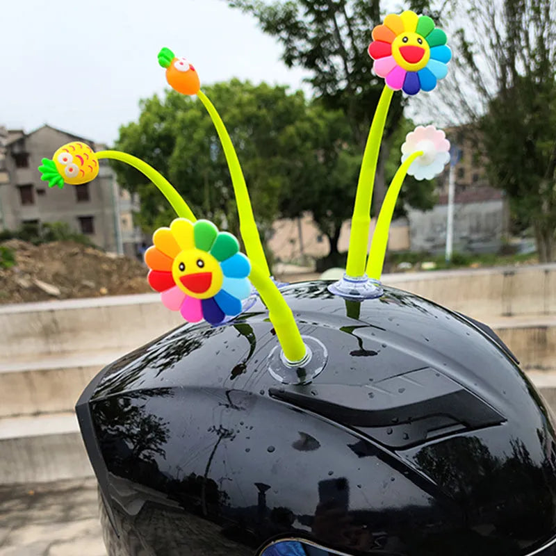 Yellow silicone sunflower decoration with suction cup for attaching to a helmet.