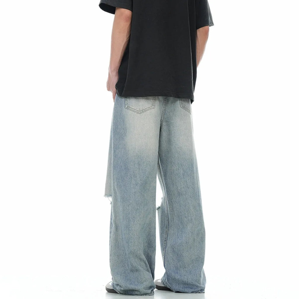 Blue wash straight-leg jeans with ripped detailing and zipper fly opening
