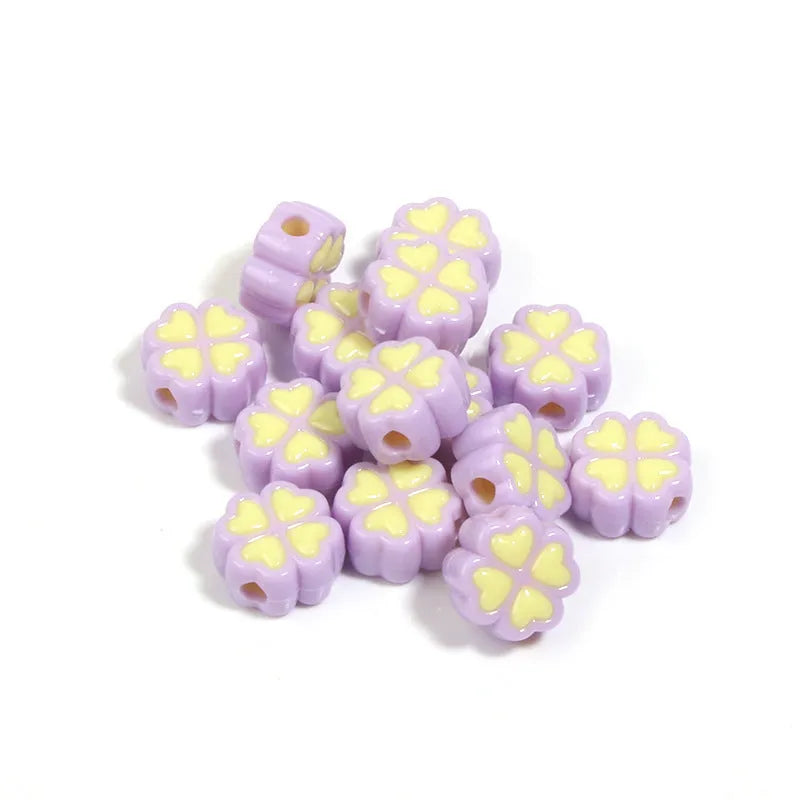 A pile of 15mm frosted acrylic four-leaf clover beads in mixed colours including pink, green, and blue.