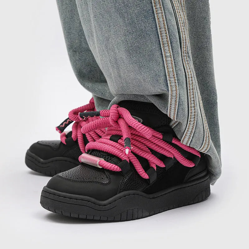 Pair of thick-soled casual lace-up shoes in a solid colour on a white background.