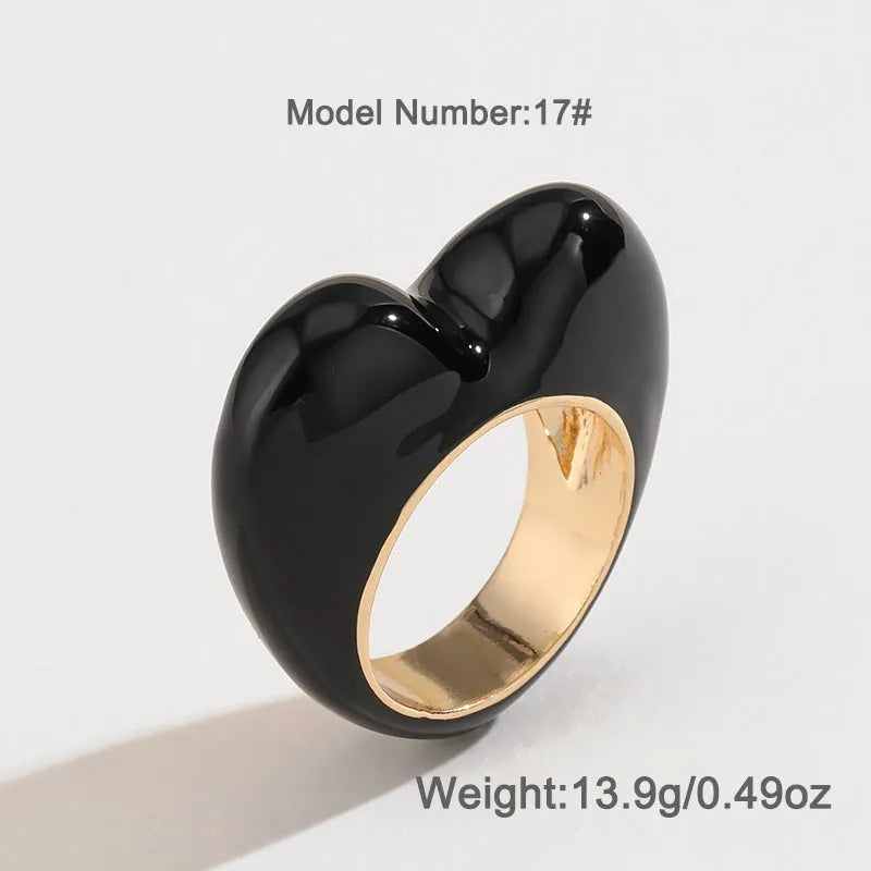 Close-up of a heart-shaped ring with a raised red enamel heart on a metallic band.