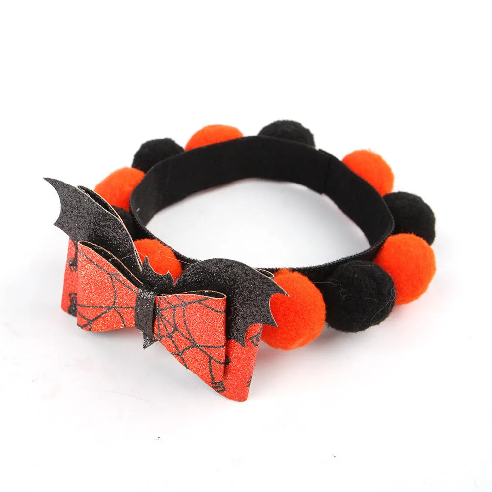 Halloween dog collar with a large orange pom-pom and pumpkin design on an adjustable black band.