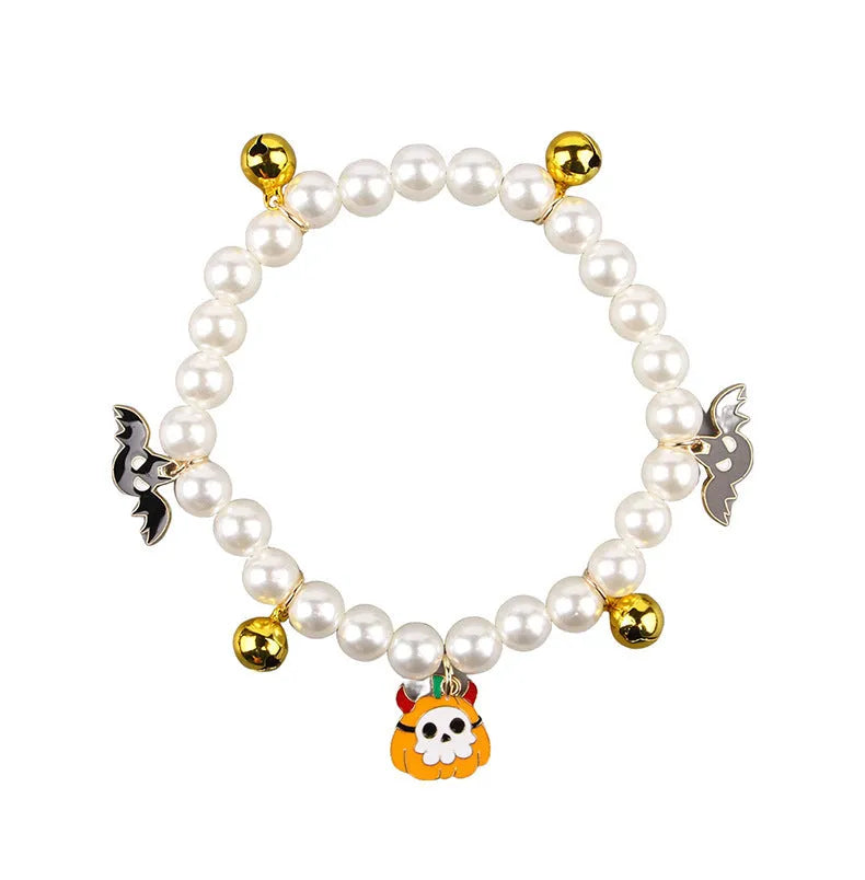 Purple simulated pearl cat collar with three Halloween pumpkin charms: ghost, skull, and smiley face.
