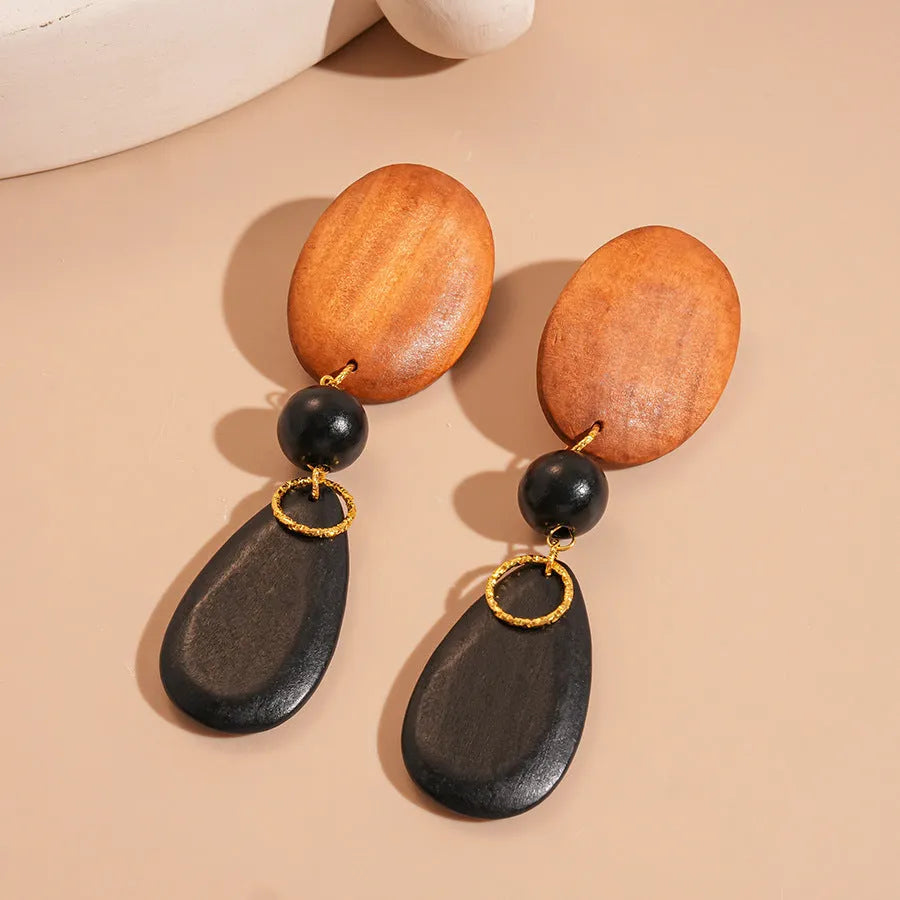 Brown-black wooden earrings with elliptical design and silver needle details for women