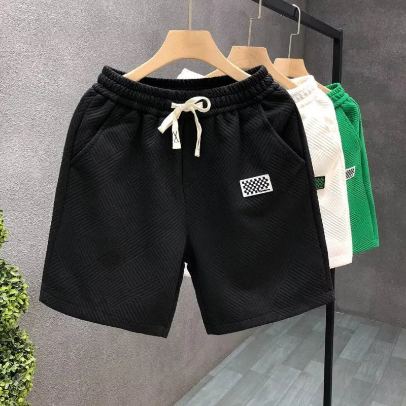 Men's solid colour polyester sports shorts with micro elasticity in white, black, or green.