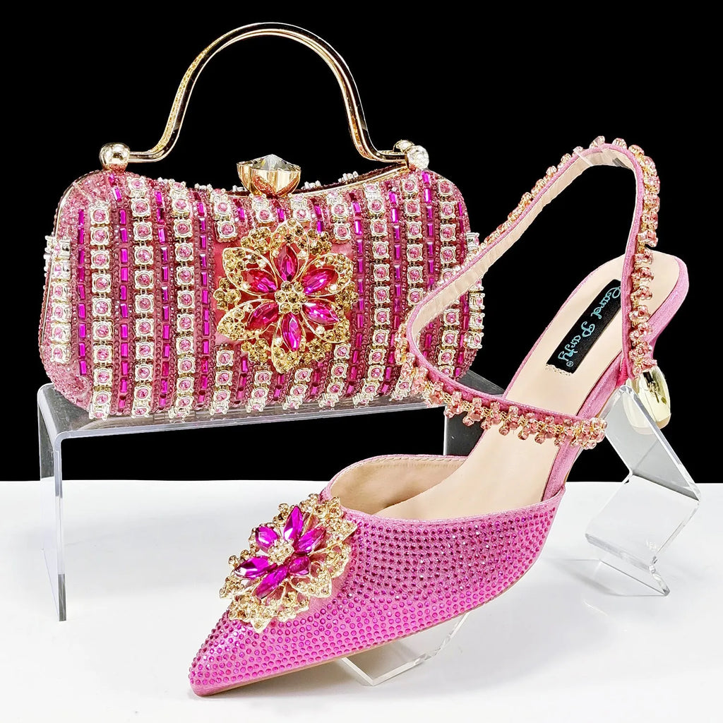 Women's black synthetic leather high heels with ankle chain and matching clutch bag with rhinestone flower decoration