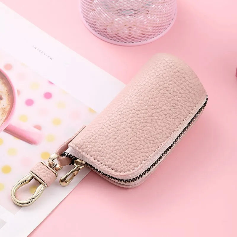 Simple black PU zipper key ring case for car and home keys on a grey background.