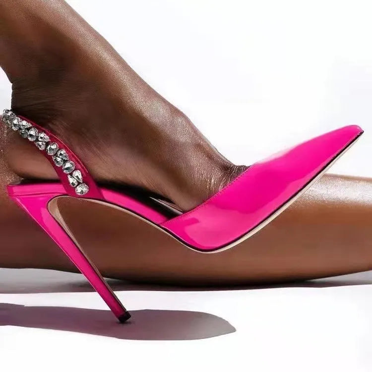 Women's black patent leather pointed toe stiletto sandals with rhinestone decorations along the side.