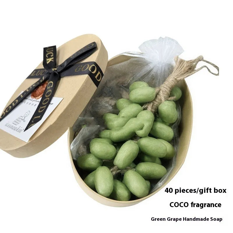Handmade grape soap bars in black, green, and purple grape scents alongside litchi soap, with gift box and mesh bag packaging