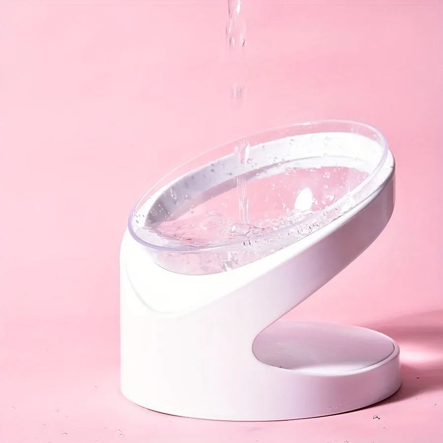 Clear plastic tilted cat food bowl on a flat surface