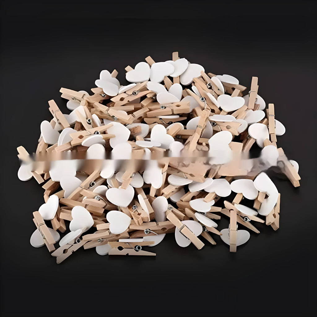 Five handmade wooden heart-shaped clips in red, white, and rose red on a plain background.