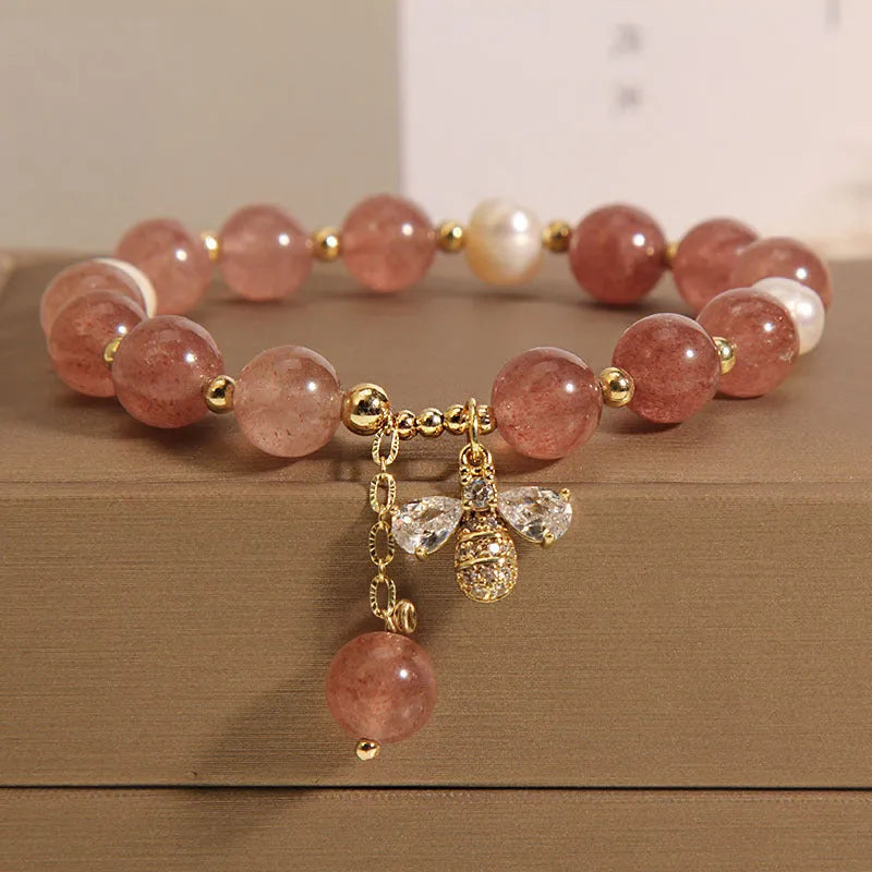 Strawberry quartz and freshwater pearl bracelet with zircon accents on woman's wrist