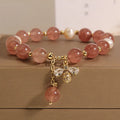 Strawberry quartz and freshwater pearl bracelet with zircon accents on woman's wrist