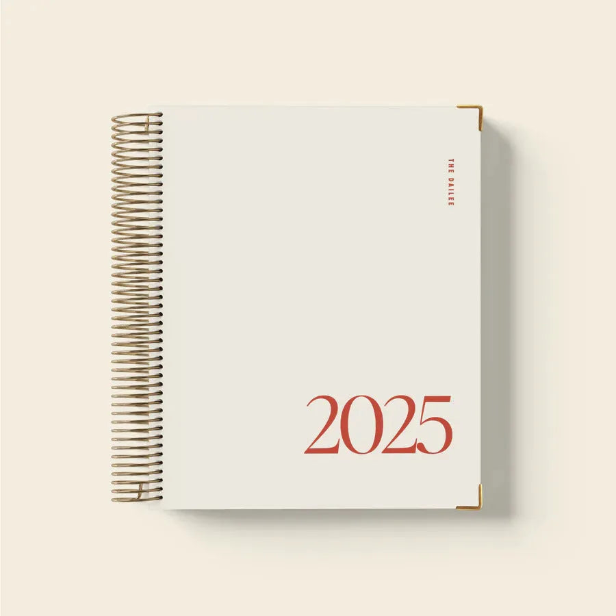 Cherry red spiral bound daily planner notebook with A5 paper pages open on desk