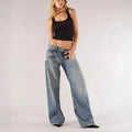 Women's blue cotton wide-leg mop trousers with a loose fit and low waist on a neutral background.