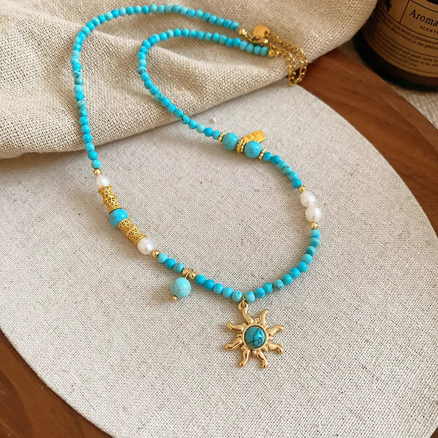 French royal style necklace with sun pendant, freshwater pearls, and adjustable metal chain.
