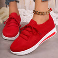 Women's low-top red fly-knit sneakers with round toe and lace-up front on a white background.
