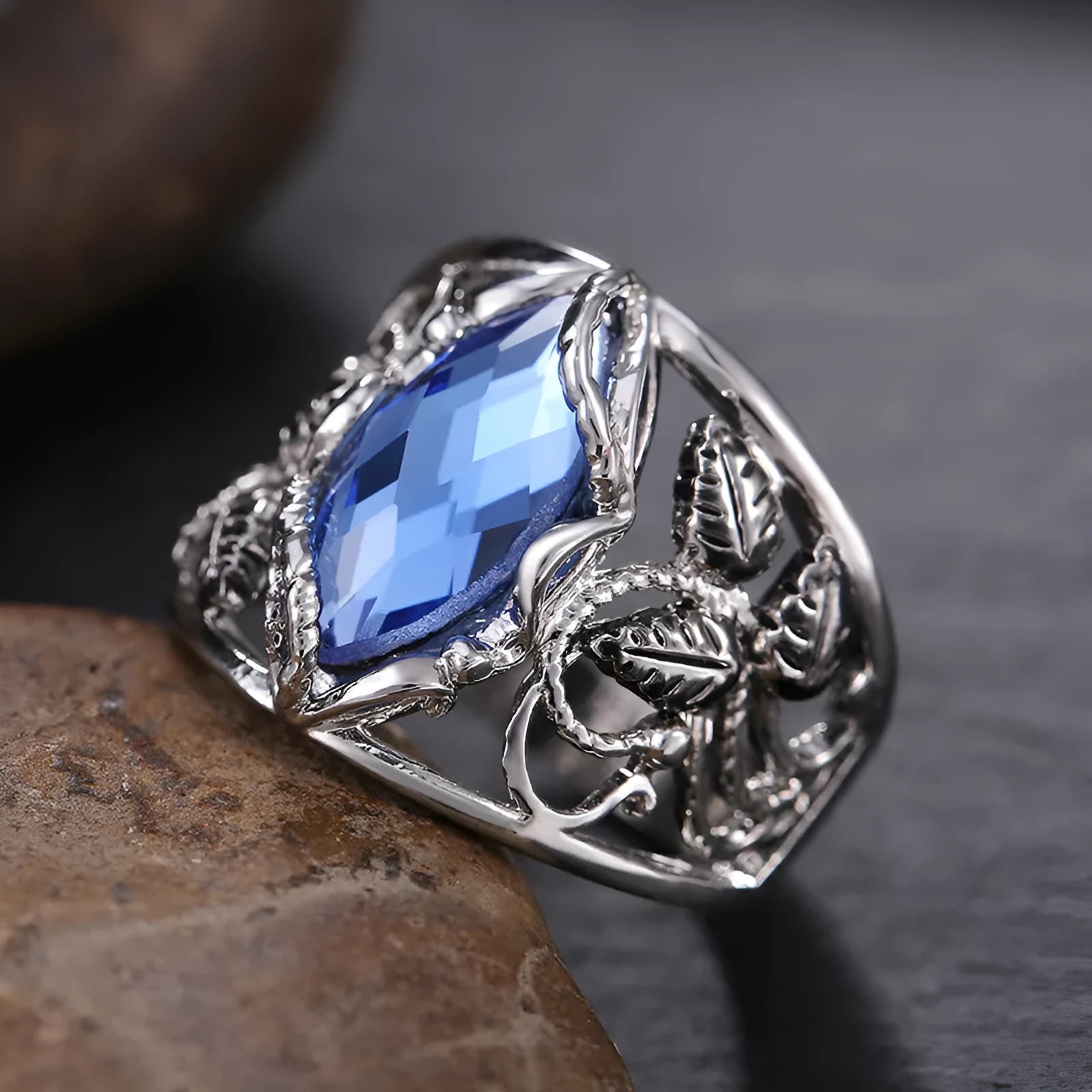 Close-up of a women's horse eye shaped blue crystal ring on a finger.