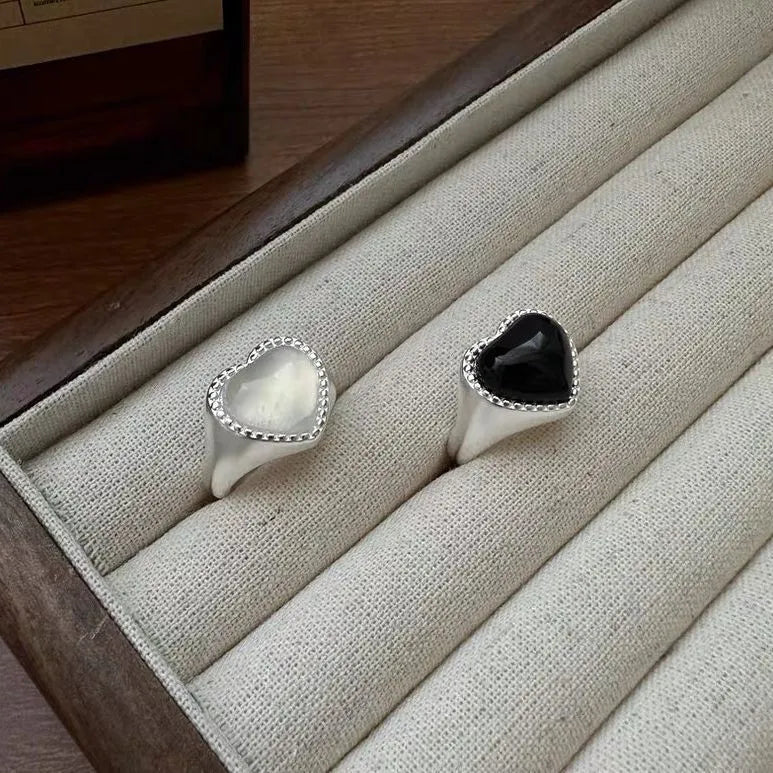 S925 sterling silver adjustable ring with a black agate heart centrepiece on a finger.