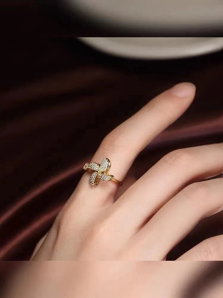 A geometric copper ring with a spinning windmill detail, shown in gold and silver electroplated finishes.