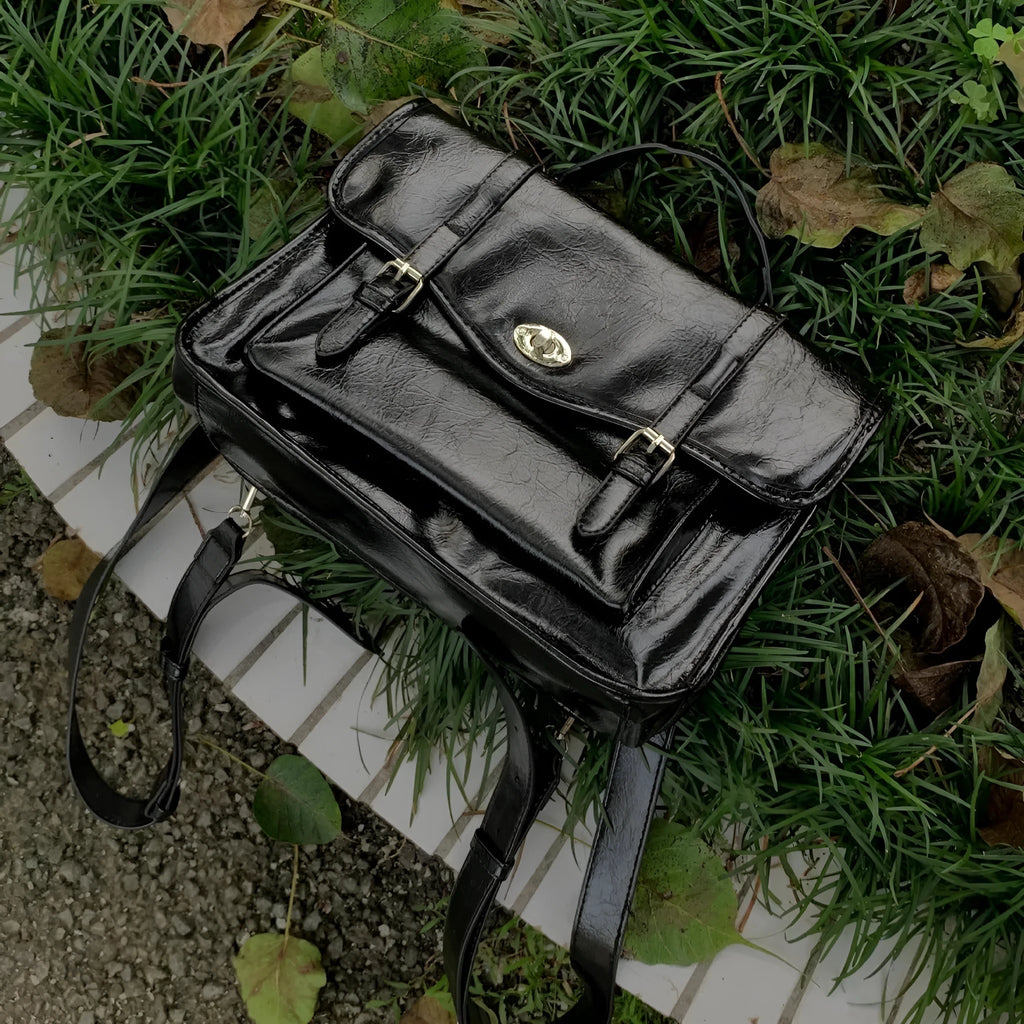 Black women's messenger bag with oil wax leather finish and adjustable crossbody strap