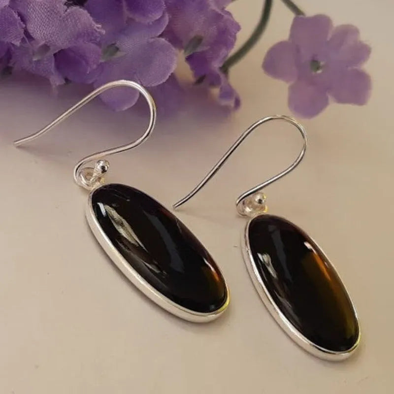 Pair of women's earrings with oval black agate pendant on silver electroplated alloy geometric setting.