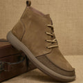 Grey genuine leather martin boots with wedge heel and front lace-up fastening on a neutral background