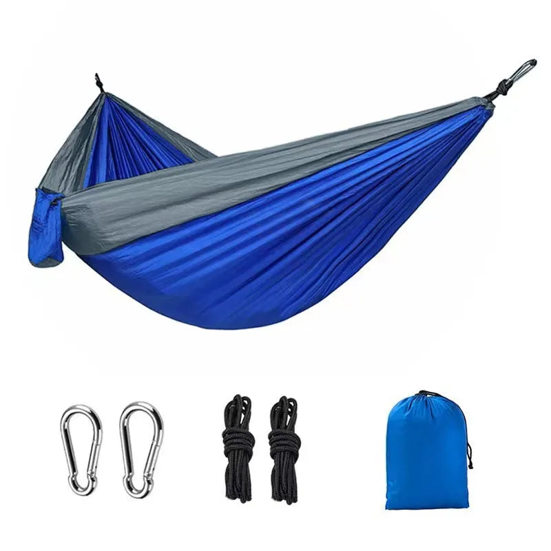 Blue nylon parachute cloth outdoor hammock with reinforced stitching hung between trees
