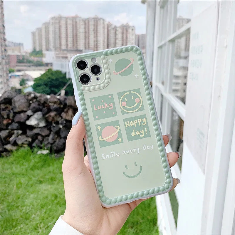 Green iPhone case with geometric shapes and smiley face pattern, TPU back cover.