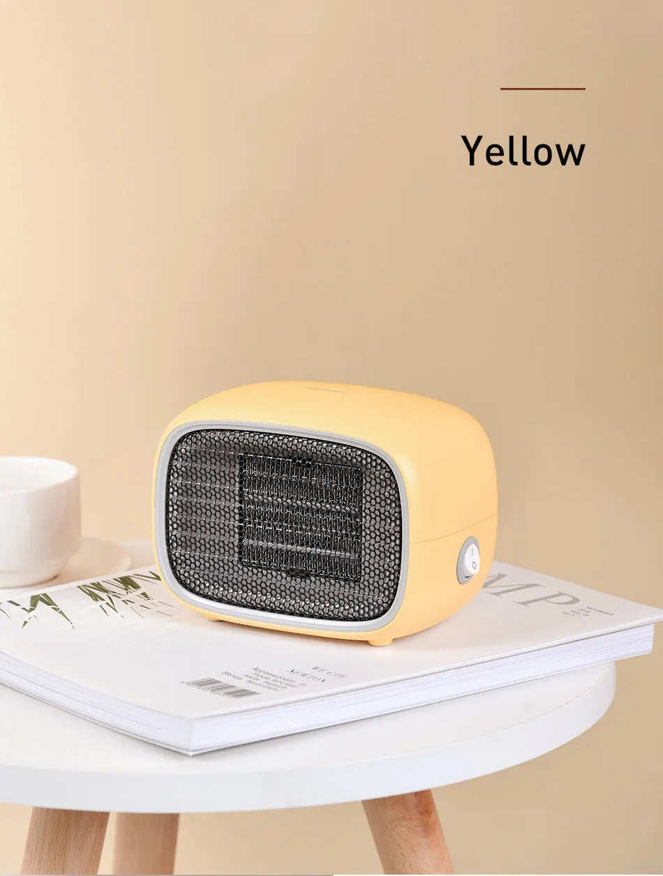 Compact green portable ceramic fan heater with metal grille, shown on a desk
