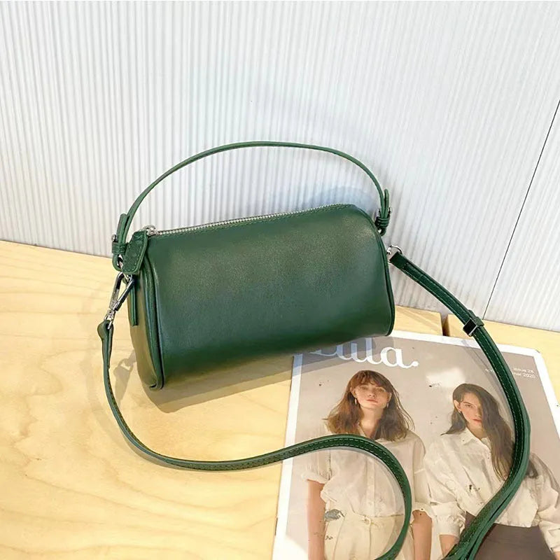 Soft vegetable-tanned leather crossbody phone bag in cylindrical shape with adjustable strap.