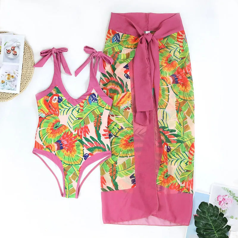 Women's pink floral print one-piece swimsuit with V-neck and a separate cover-up skirt.