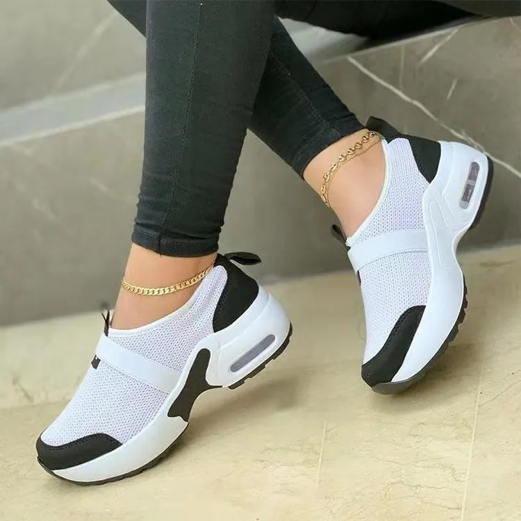Women's flat mesh sneakers in light grey with white rubber soles and colour stitching.