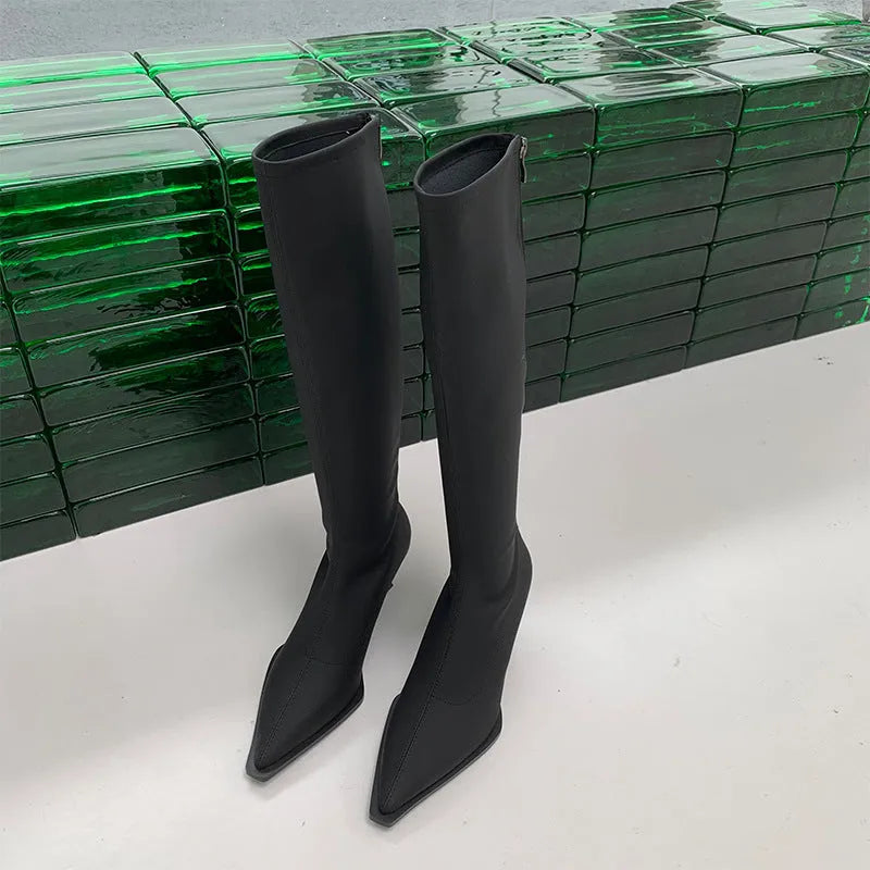 Black women's pointed toe stiletto heel boots with a back zipper, shown below the knee.