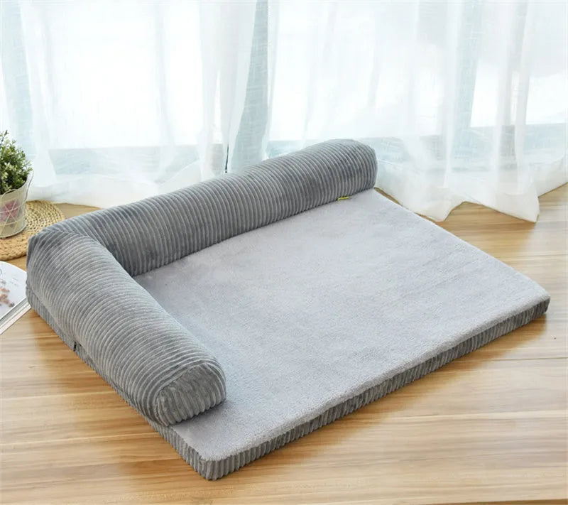 Corduroy dog bed sofa with bolster sides and non-slip base in a neutral colour.