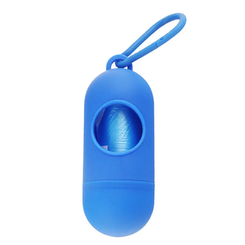 A small black plastic dog poop bag holder with a hook and Velcro strap, shown next to a roll of bags.