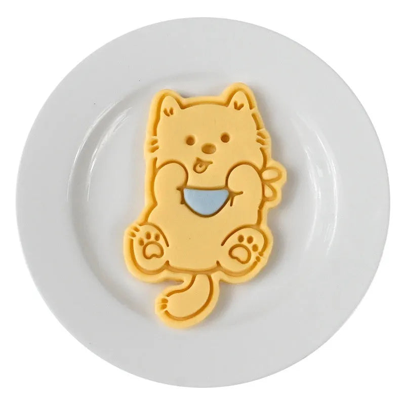 Three dimensional plastic biscuit mould showing puppy cartoon designs including birthday hats and swimming rings
