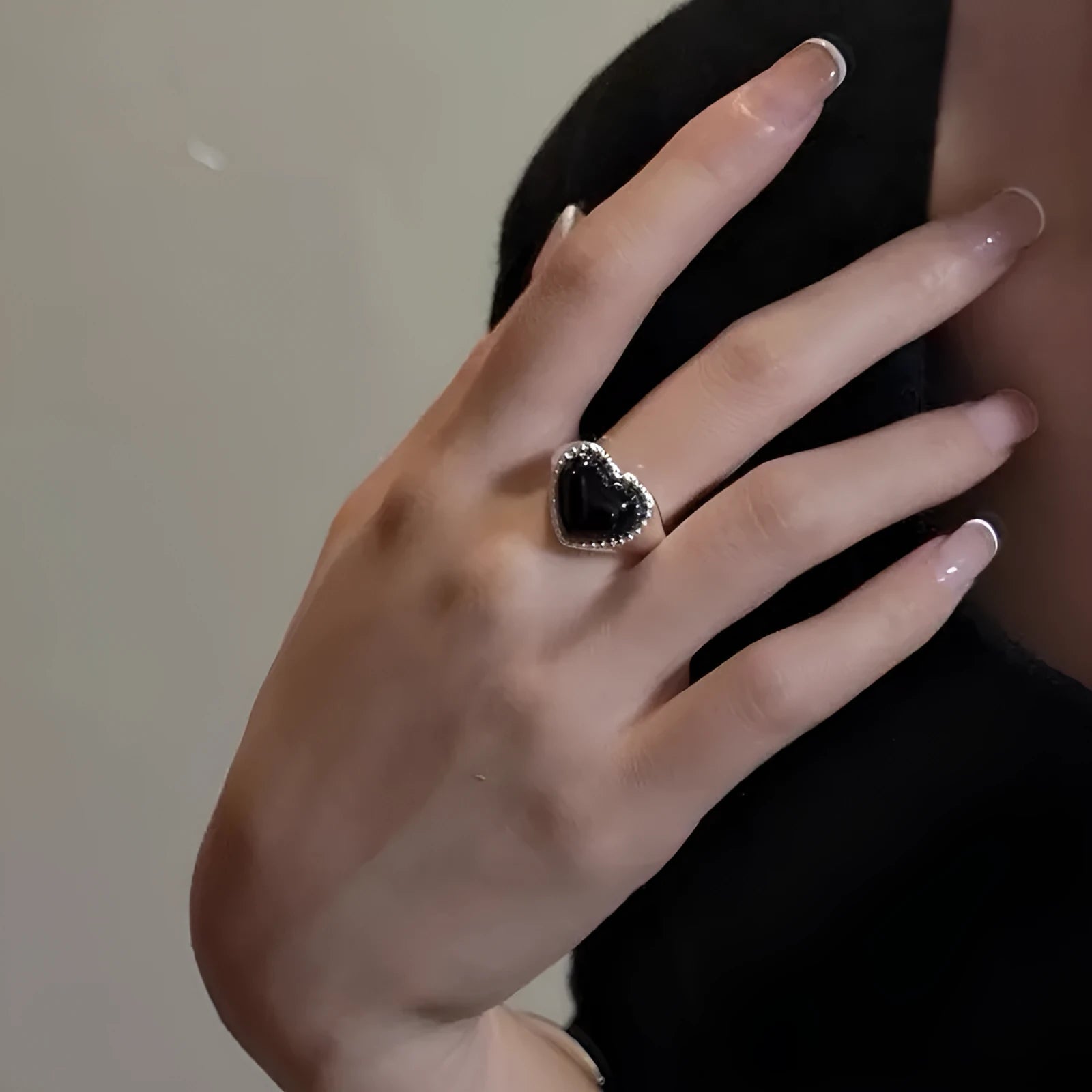 S925 sterling silver adjustable ring with a black agate heart centrepiece on a finger.