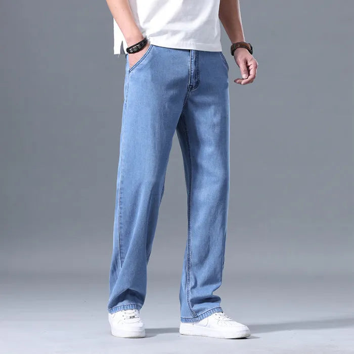 Man wearing loose fit light blue straight-leg lyocell jeans with a zip fly.