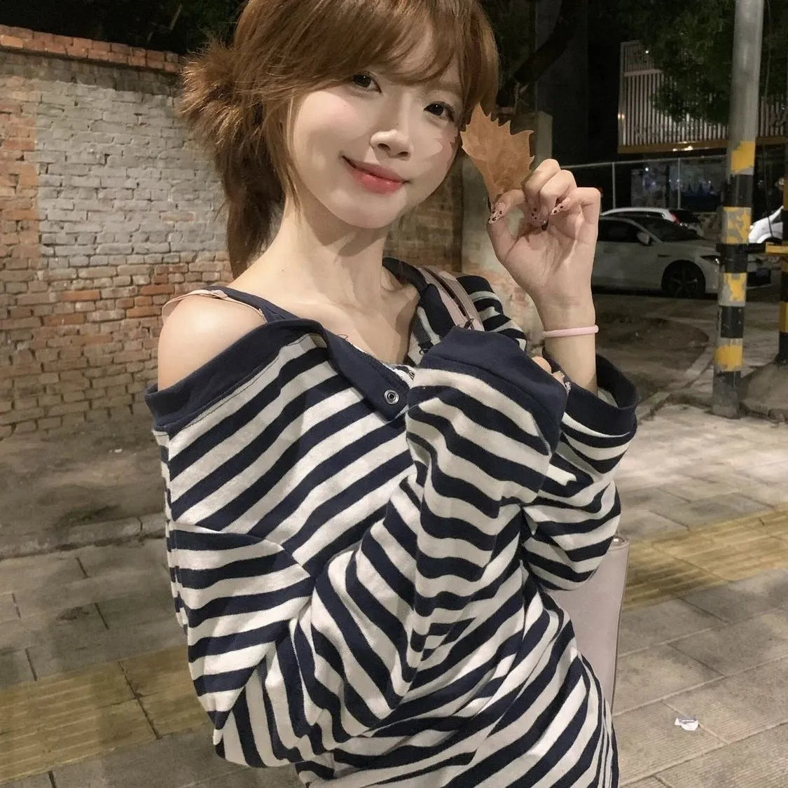 Dark blue Korean-style oversized women's long-sleeved t-shirt with embroidered stripes and button details.