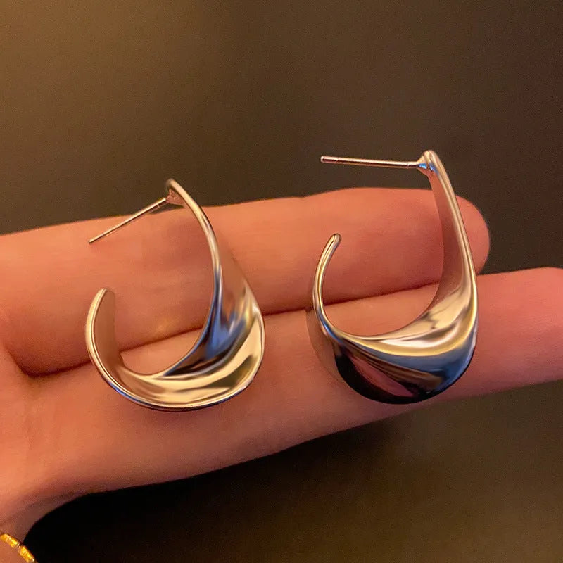 Metal twisted geometry earrings with round element in gold or silver electroplated finish