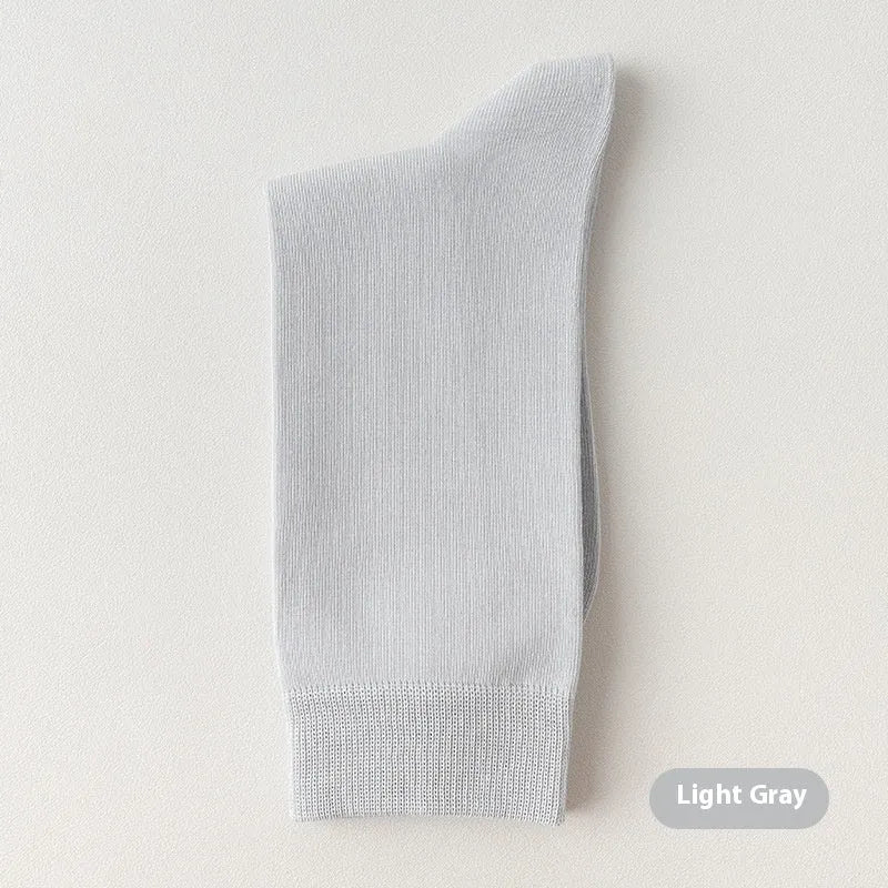 Men's solid colour pure cotton mid-calf business socks in beige, black, grey and blue shown folded.