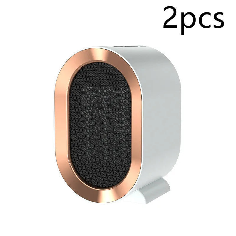Compact black desktop electric ceramic fan heater with mechanical controls on a wooden desk