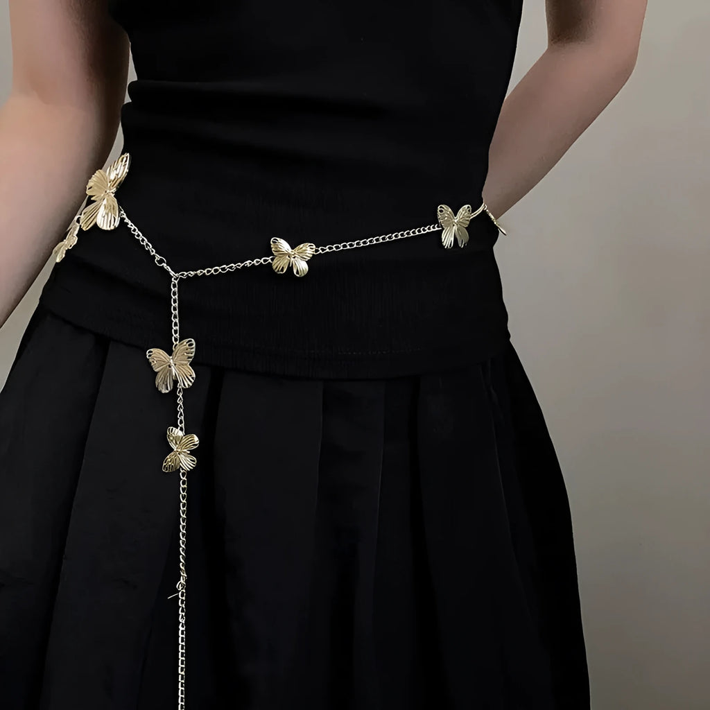 Gold and silver butterfly motif waist chain jewellery belt for women on a plain background.