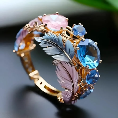 Gold-coloured brass feather ring with geometric embossed design and inlaid zircon stones