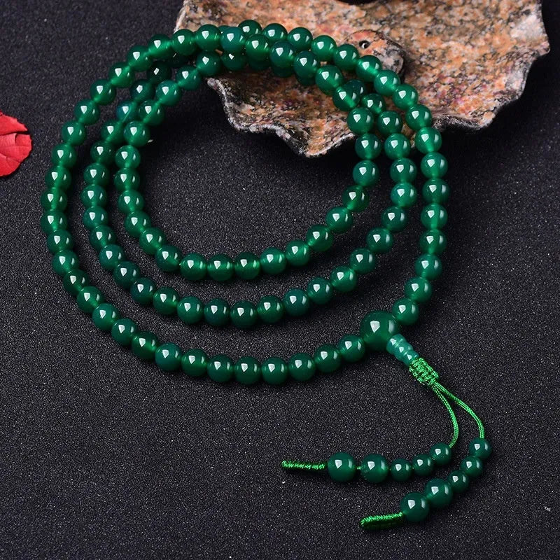Handmade green agate bracelet with a detailed thangka pendant and multi-circle bead design.